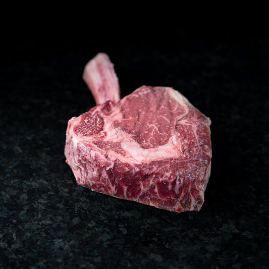 American Wagyu cowboy ribeye steak with impressive bone-in presentation, rich marbling, and bold flavor - perfect for grilling