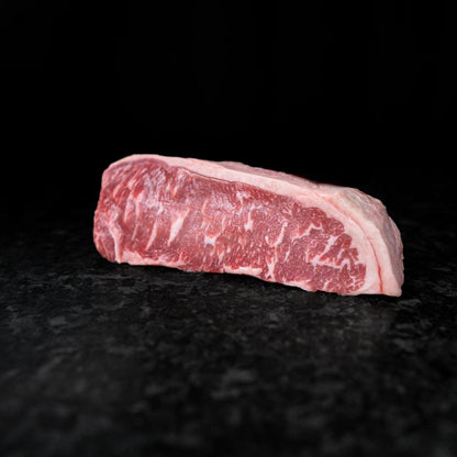 American Wagyu New York Strip Steak with bold marbling and rich flavor, ideal for grilling