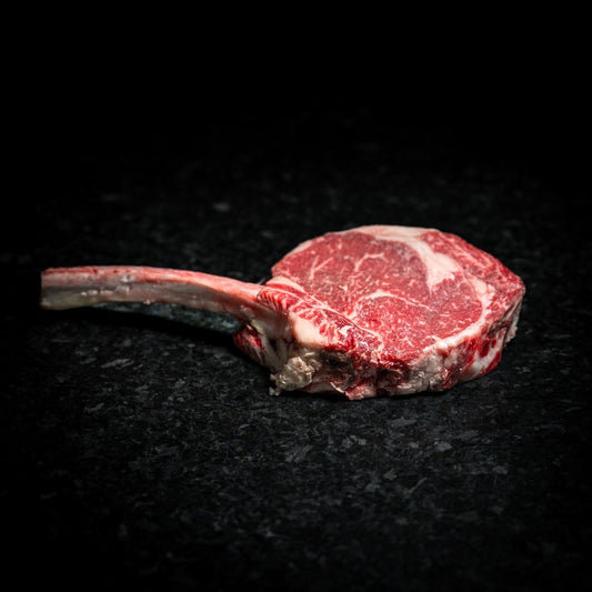 American Wagyu tomahawk steak with long bone and intense marbling, perfect for reverse searing or grilling