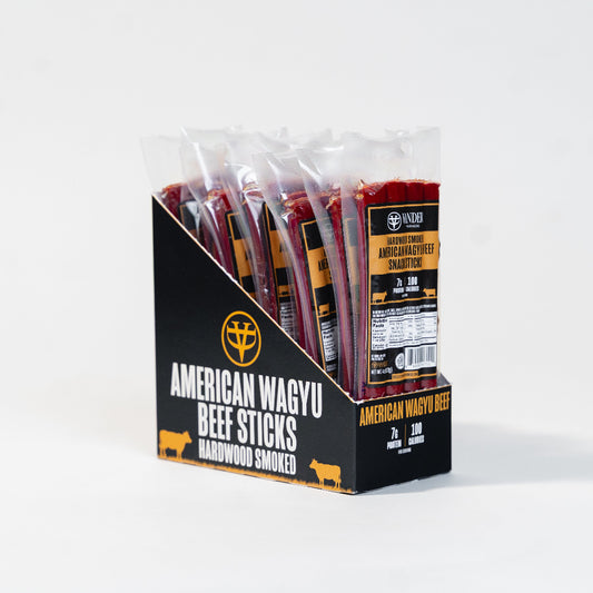 Packaged American Wagyu beef sticks in a clear plastic box with a black label on a white background.